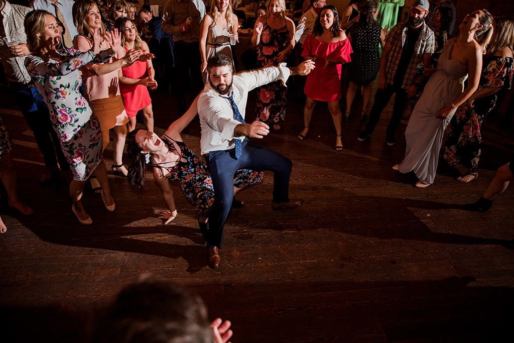 People dancing and having fun at a lively party or dance event in a dimly lit venue.