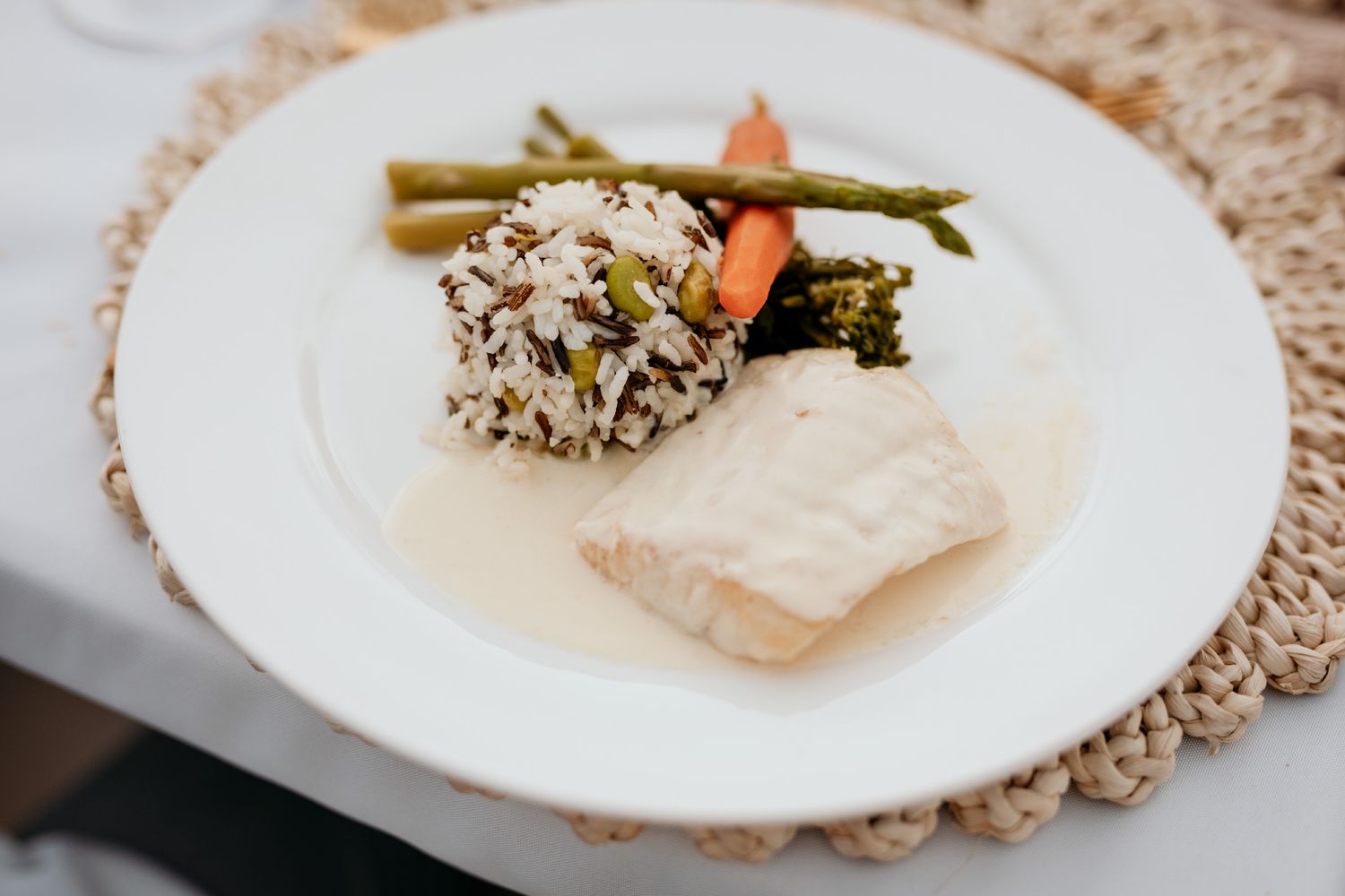 An elegant dish of halibut, wild rice, asparagus and carrots.