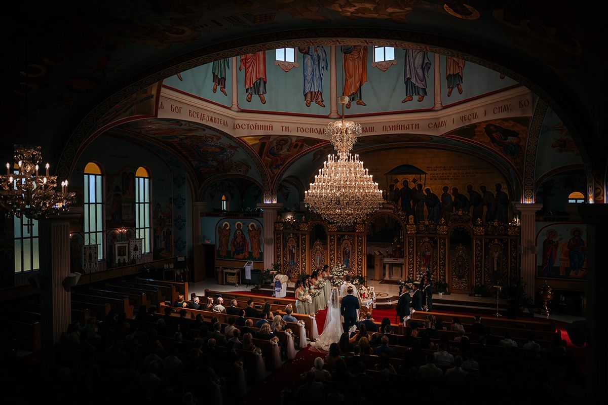 Elegant church wedding venue with crystal chandeliers and dramatic mood lighting creates a romantic atmosphere.