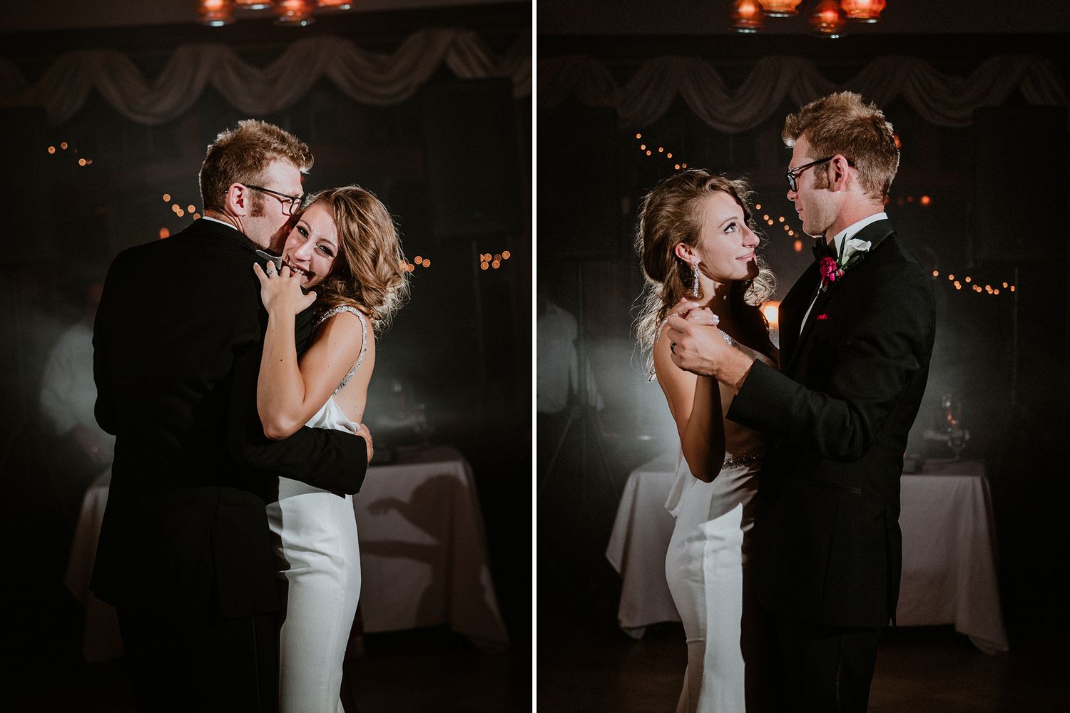 A romantic first dance between newlyweds in a dimly lit reception venue with warm glowing lights in the background.