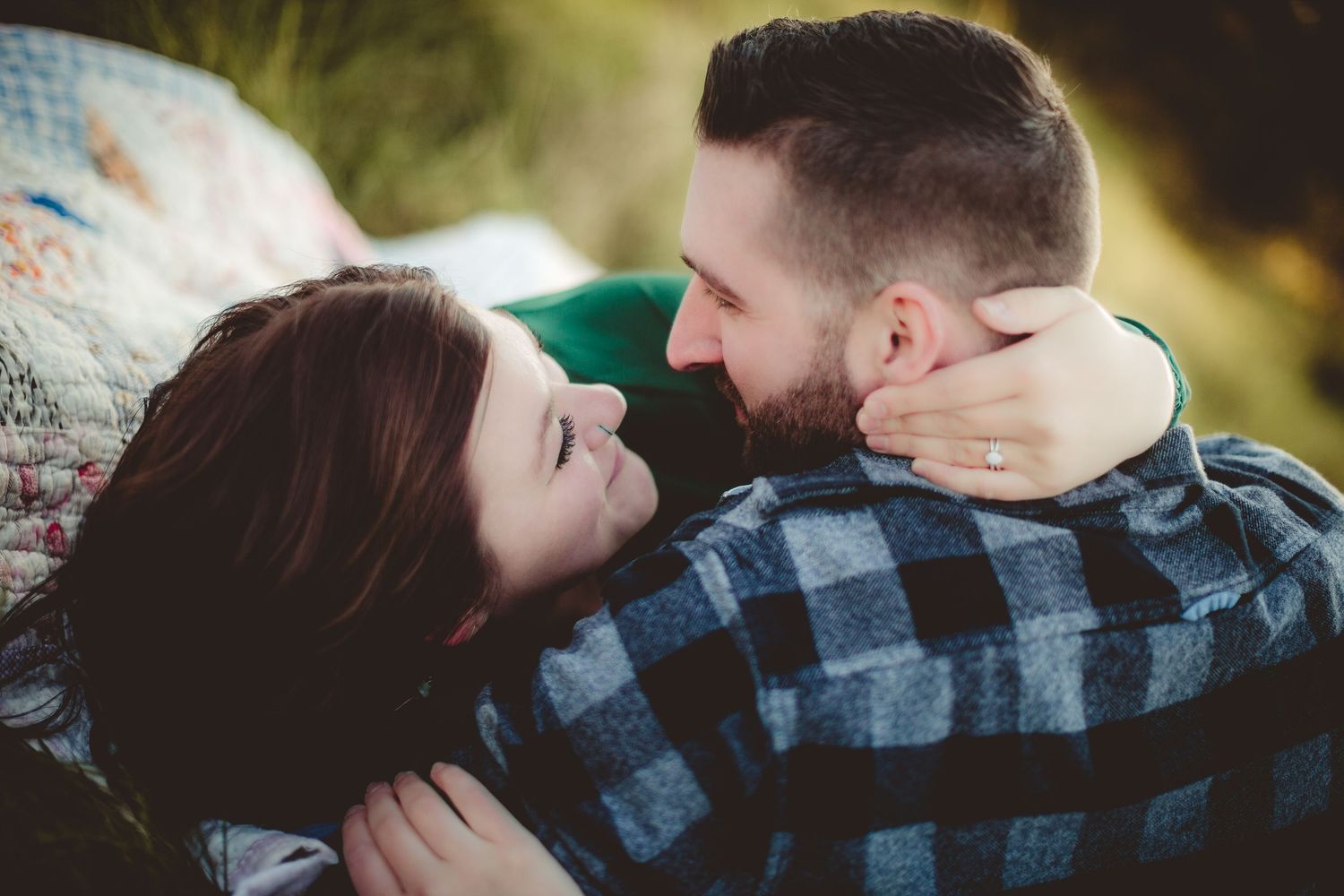 Intimate portrait of couple looking at each other while resting outdoors.