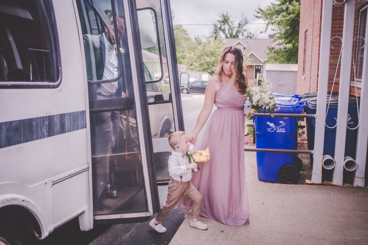 Wedding party members entering and exiting decorated shuttle bus.