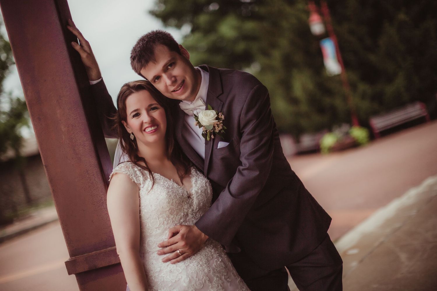 Candid wedding moments captured under rustic covered walkway during photo session.