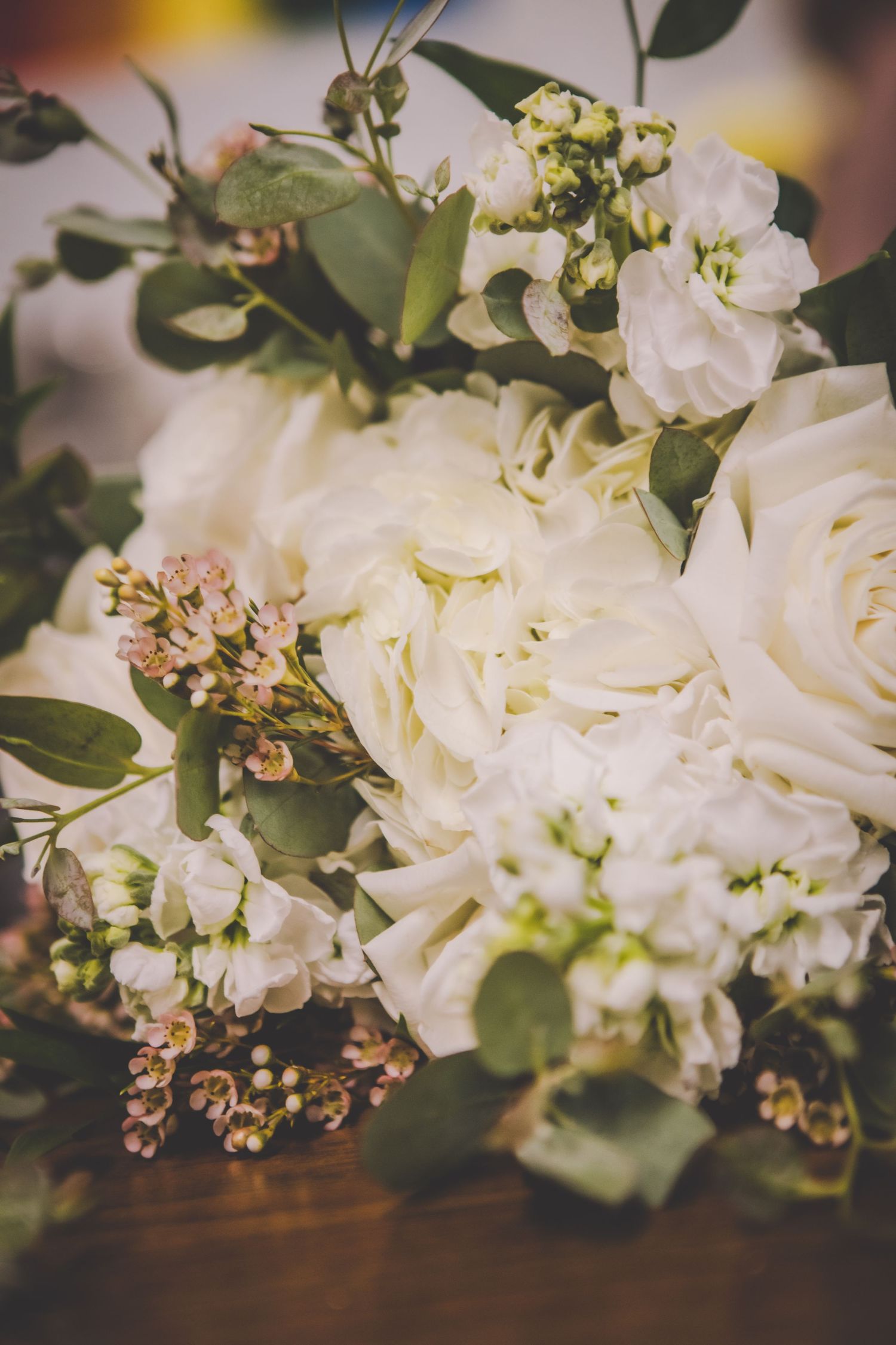 Close-up of white roses and greenery in a romantic wedding bouquet arrangement.