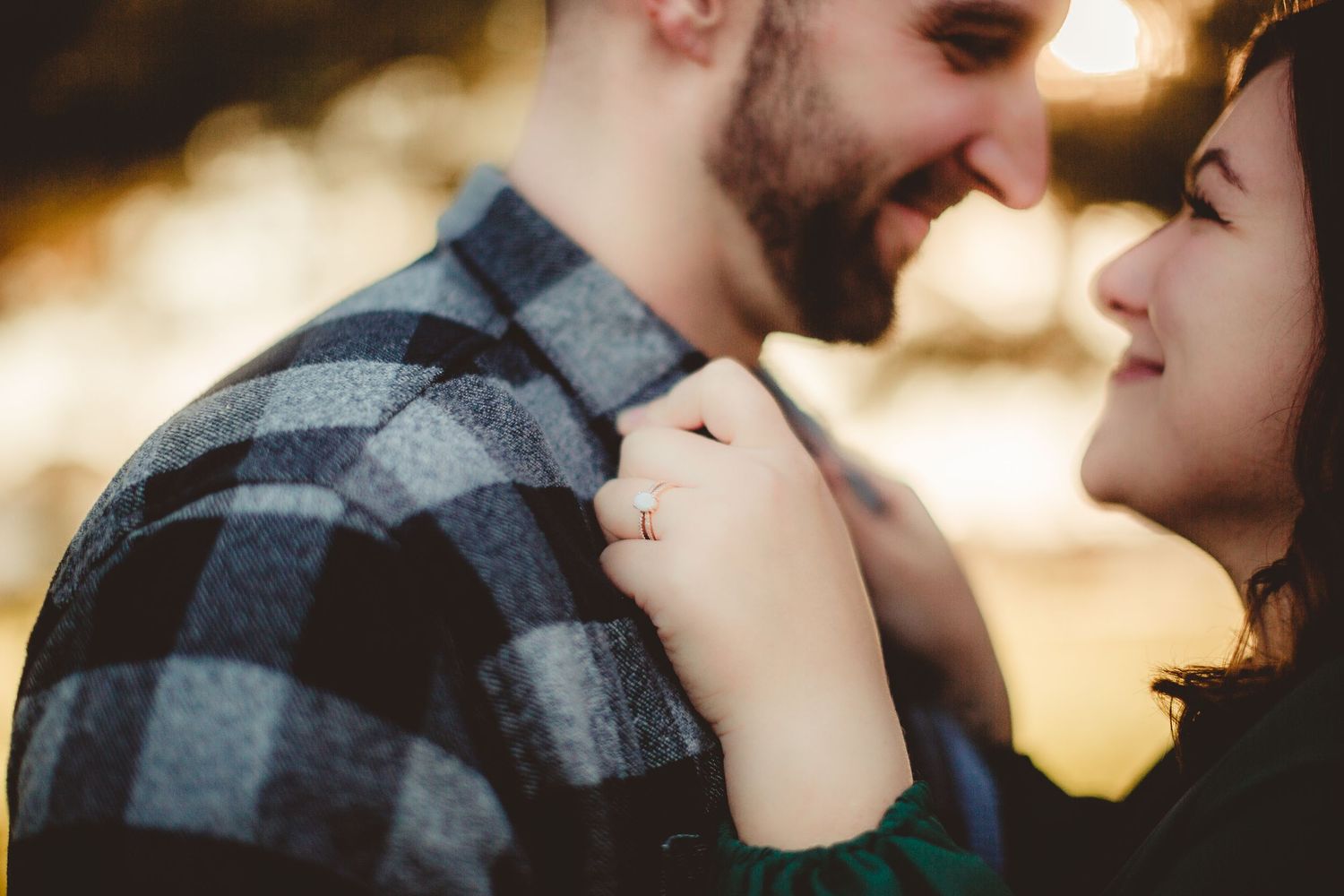 Couple sharing tender moment in warm sunset light during outdoor photo session.