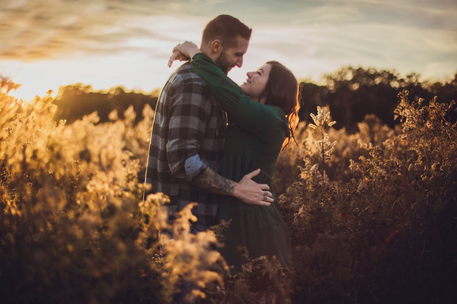 Intimate embrace captured in warm sunlight among wild autumn grasses.