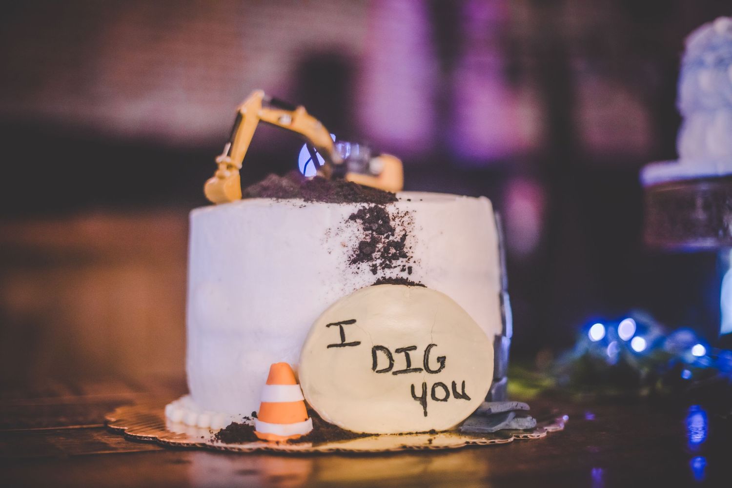 A creative wedding cake topper featuring a construction excavator and 'I dig you' message.