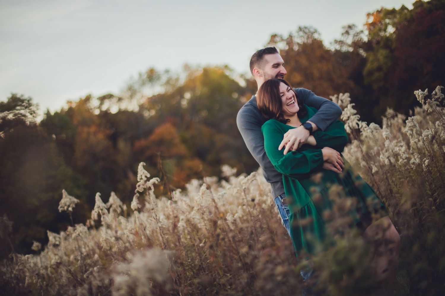 A sweet moment captured between a couple in a rustic autumn field setting.