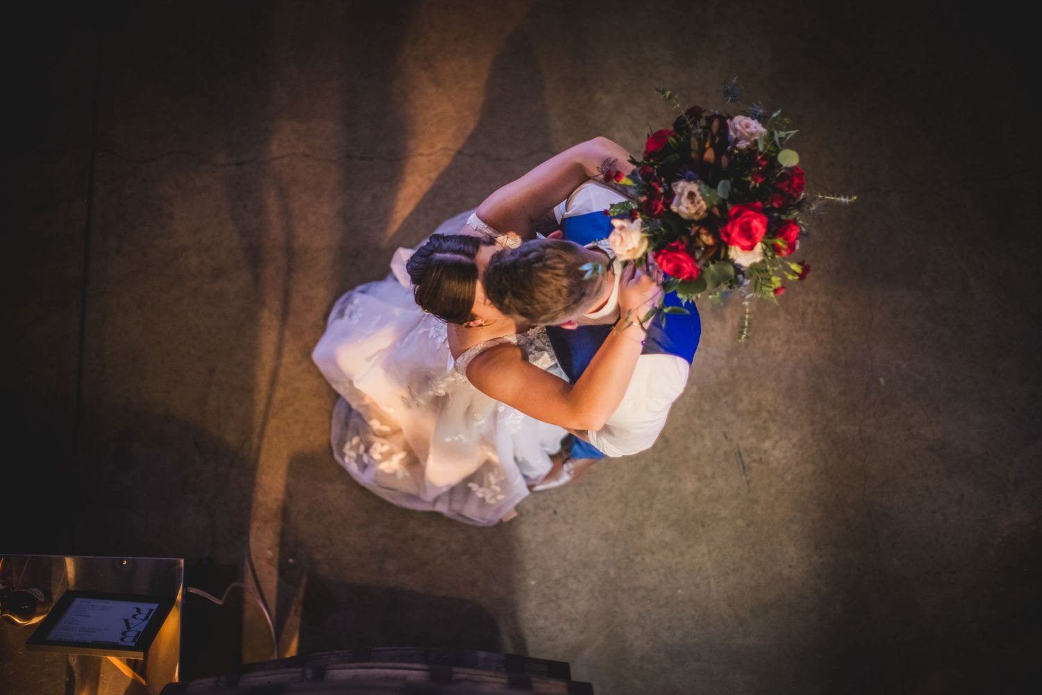 A romantic dance scene at a dimly lit wedding reception with elegant floral decor.