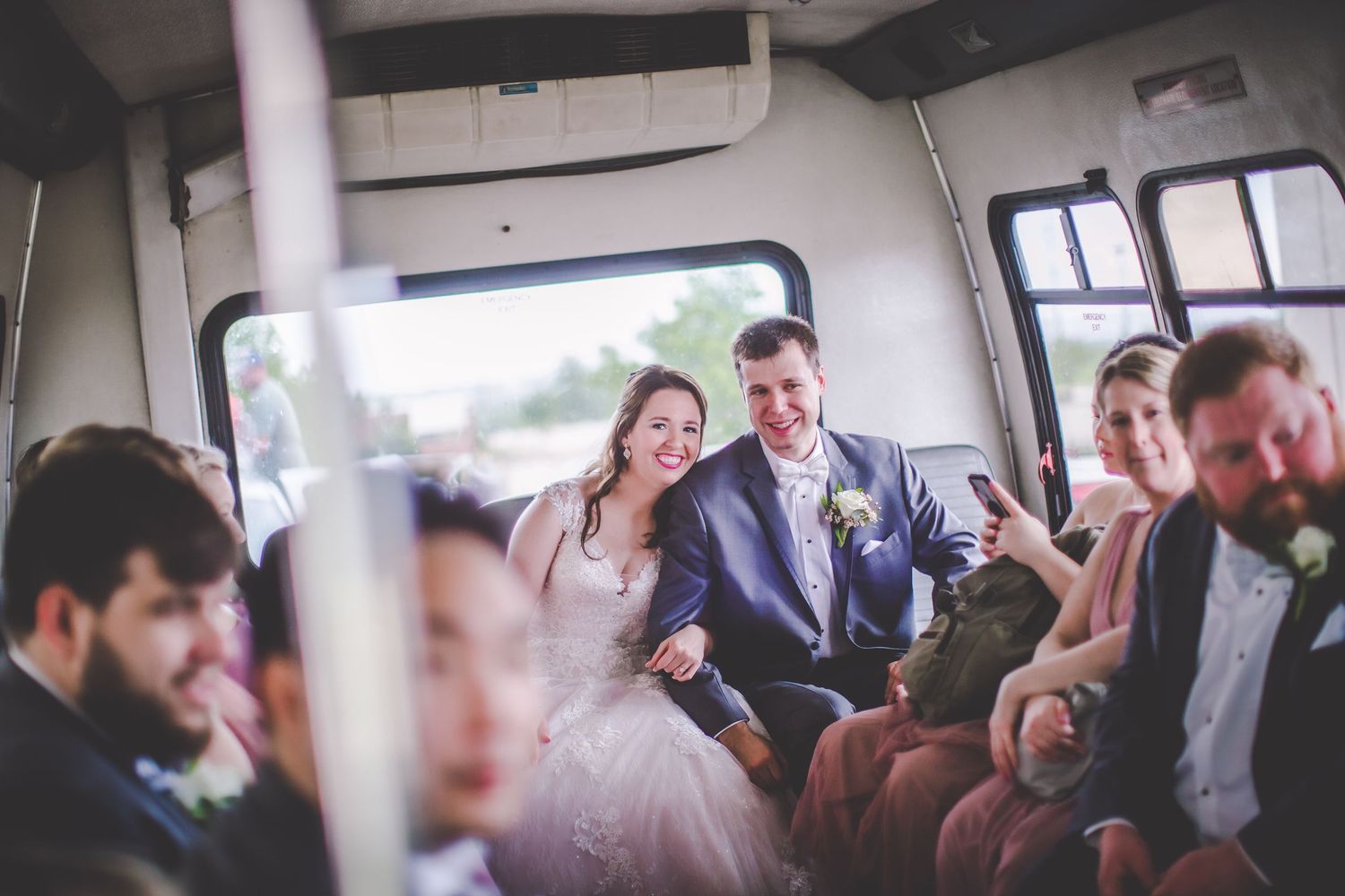 Wedding party riding together in celebration vehicle with joyful expressions.