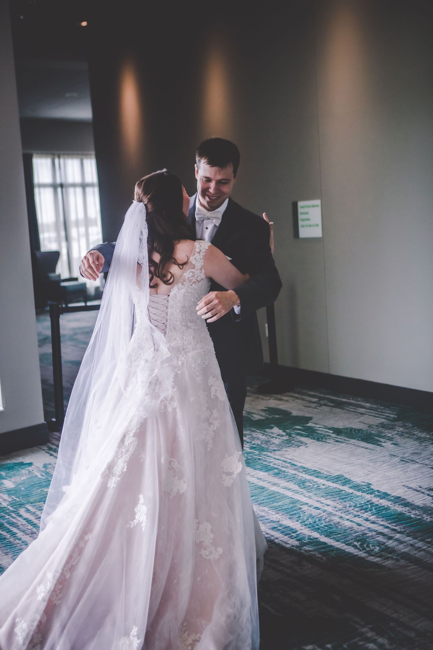 A joyful wedding moment captured as the couple embraces and laughs together.