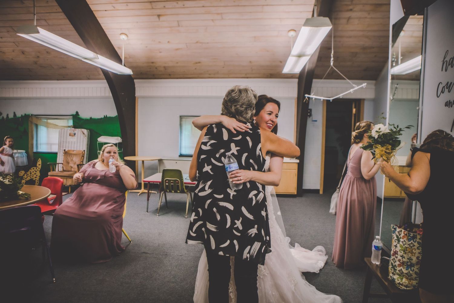 People celebrating in a reception room with floral dresses and festive atmosphere.