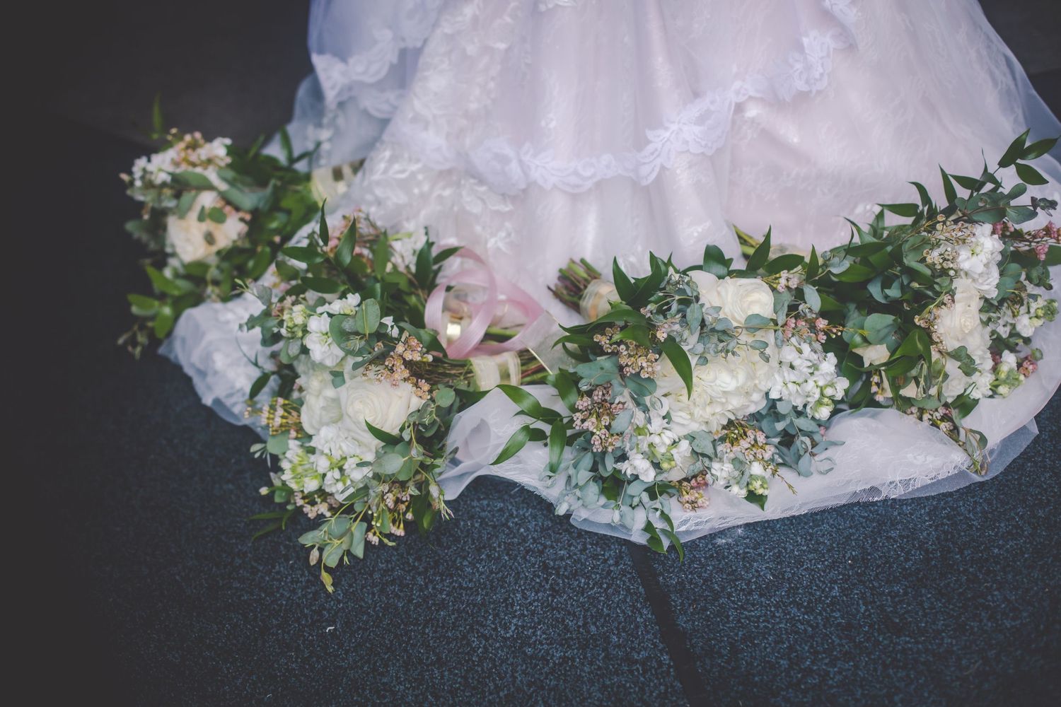 Close-up of floral arrangements decorating the hem of a wedding dress.