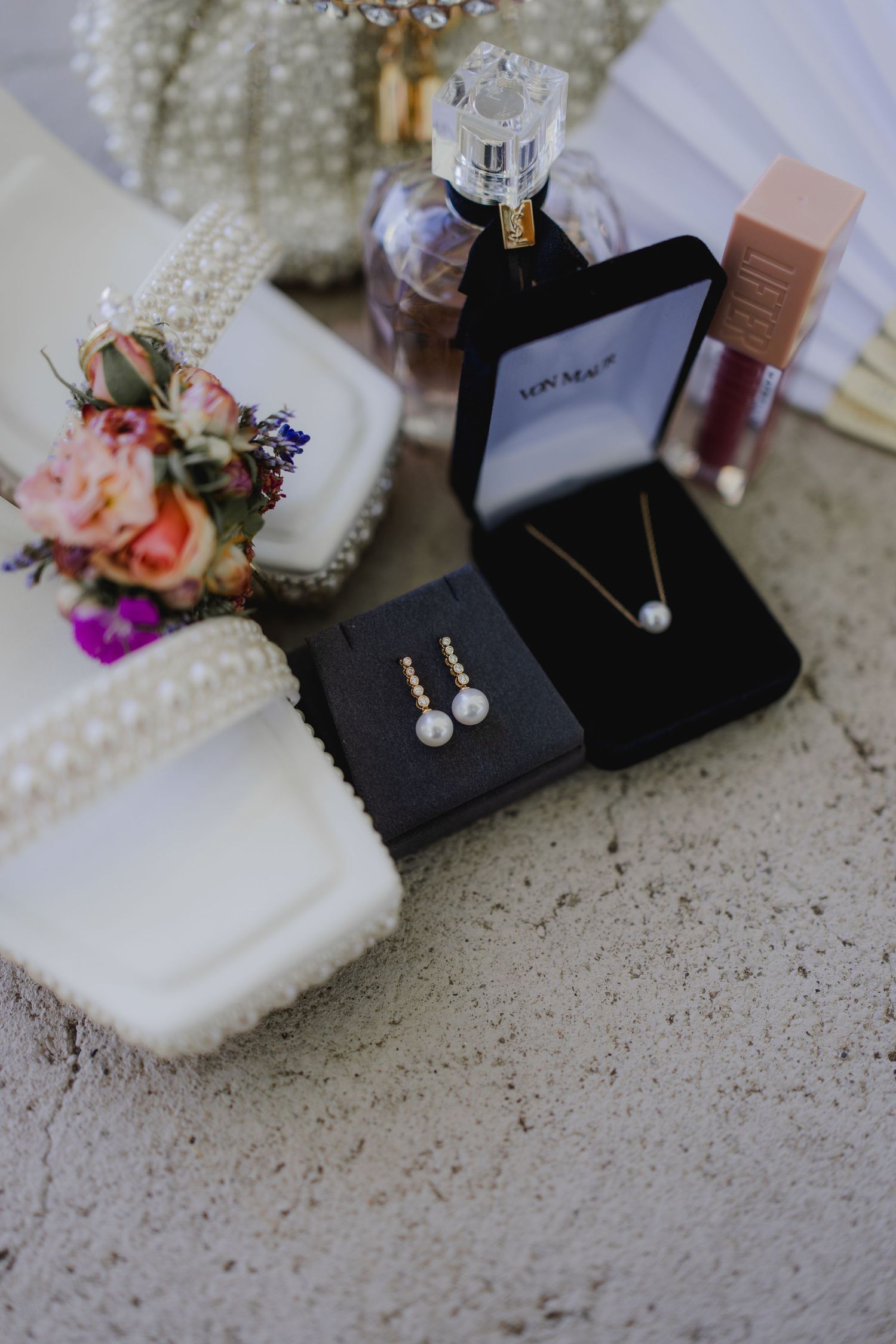 Von Maur pearl necklace and earring jewelry set in black gift boxes with perfume and flowers.