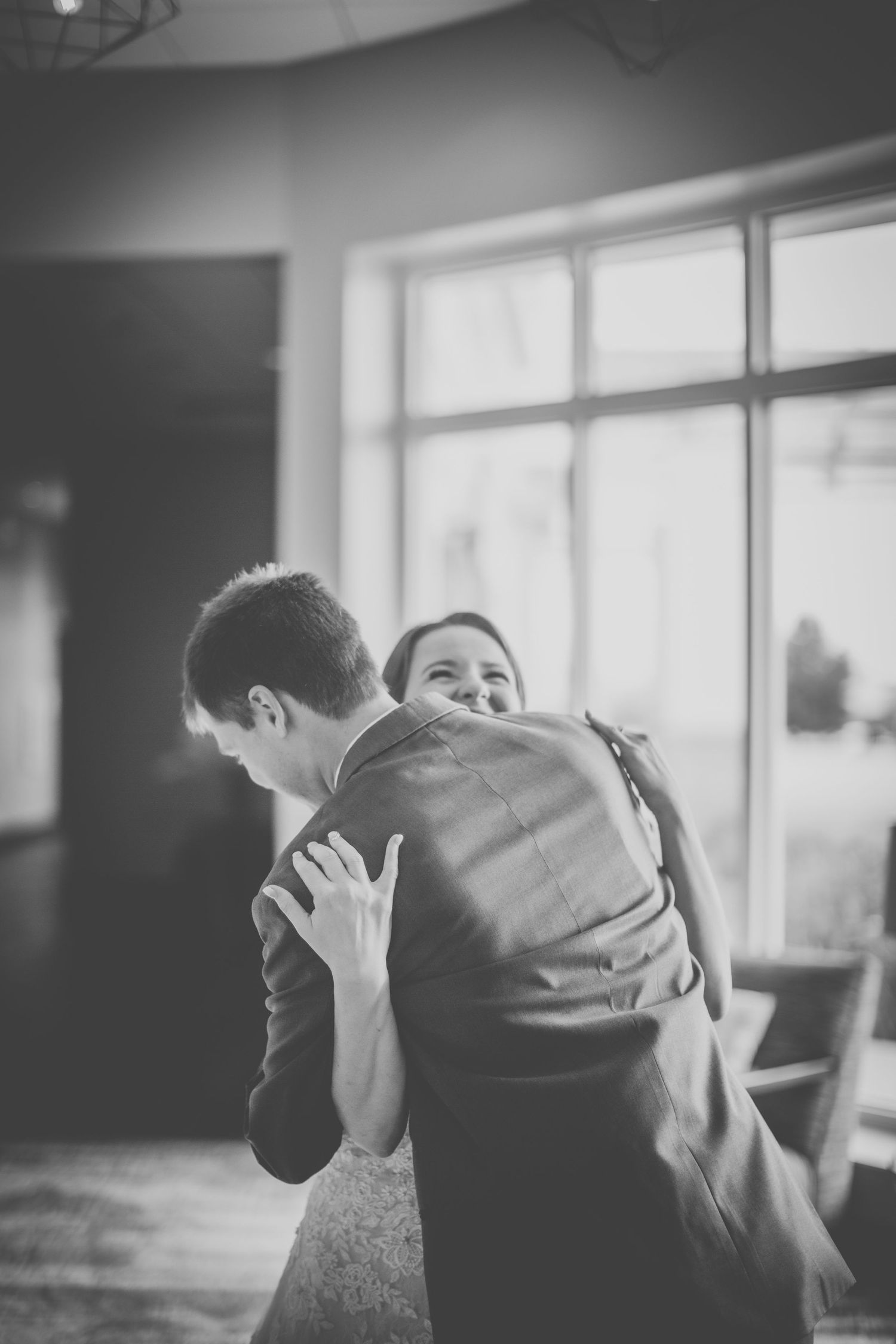 Black and white wedding first look sequence showing emotional embrace.