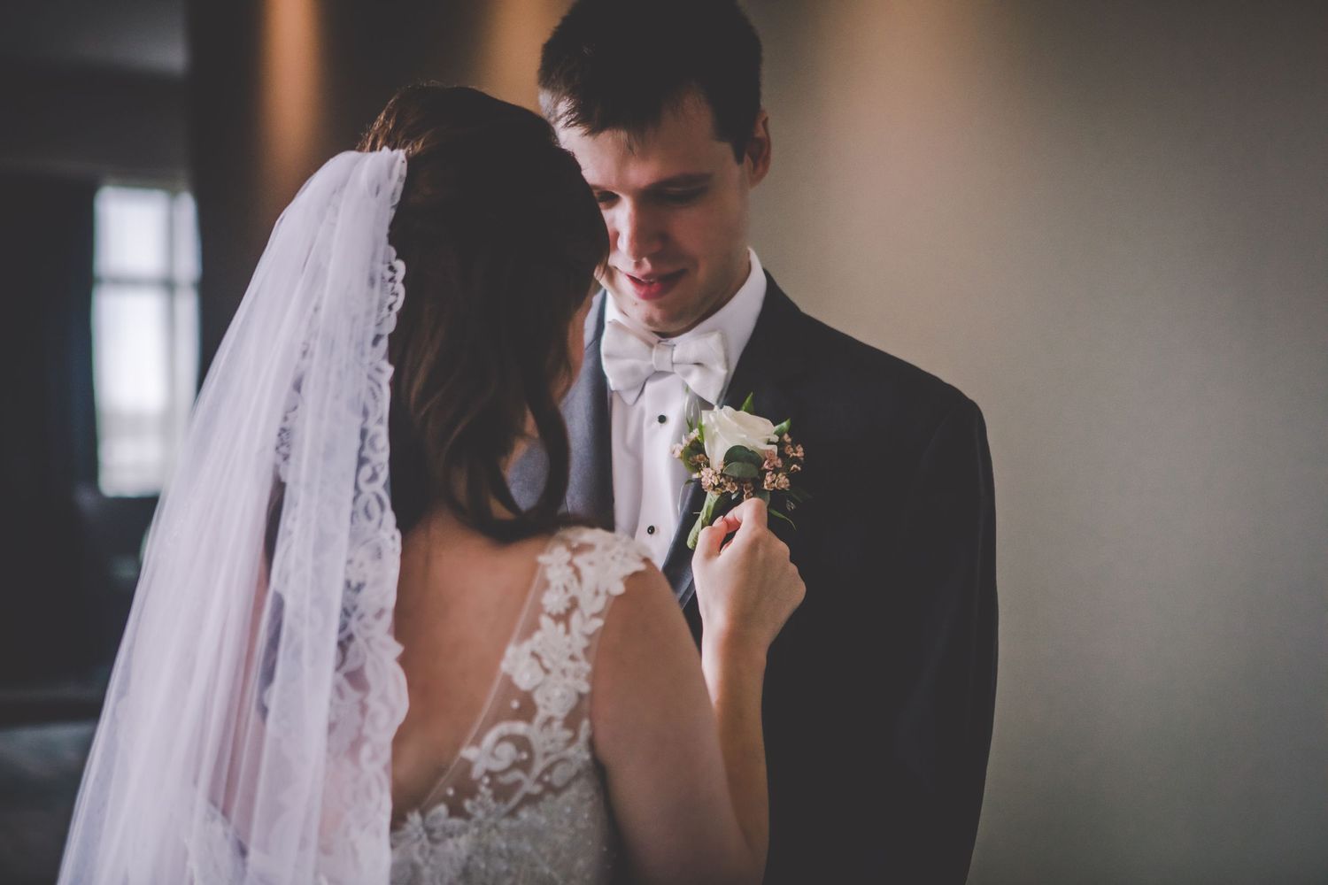 Intimate wedding portrait showing detailed lace dress and boutonniere.