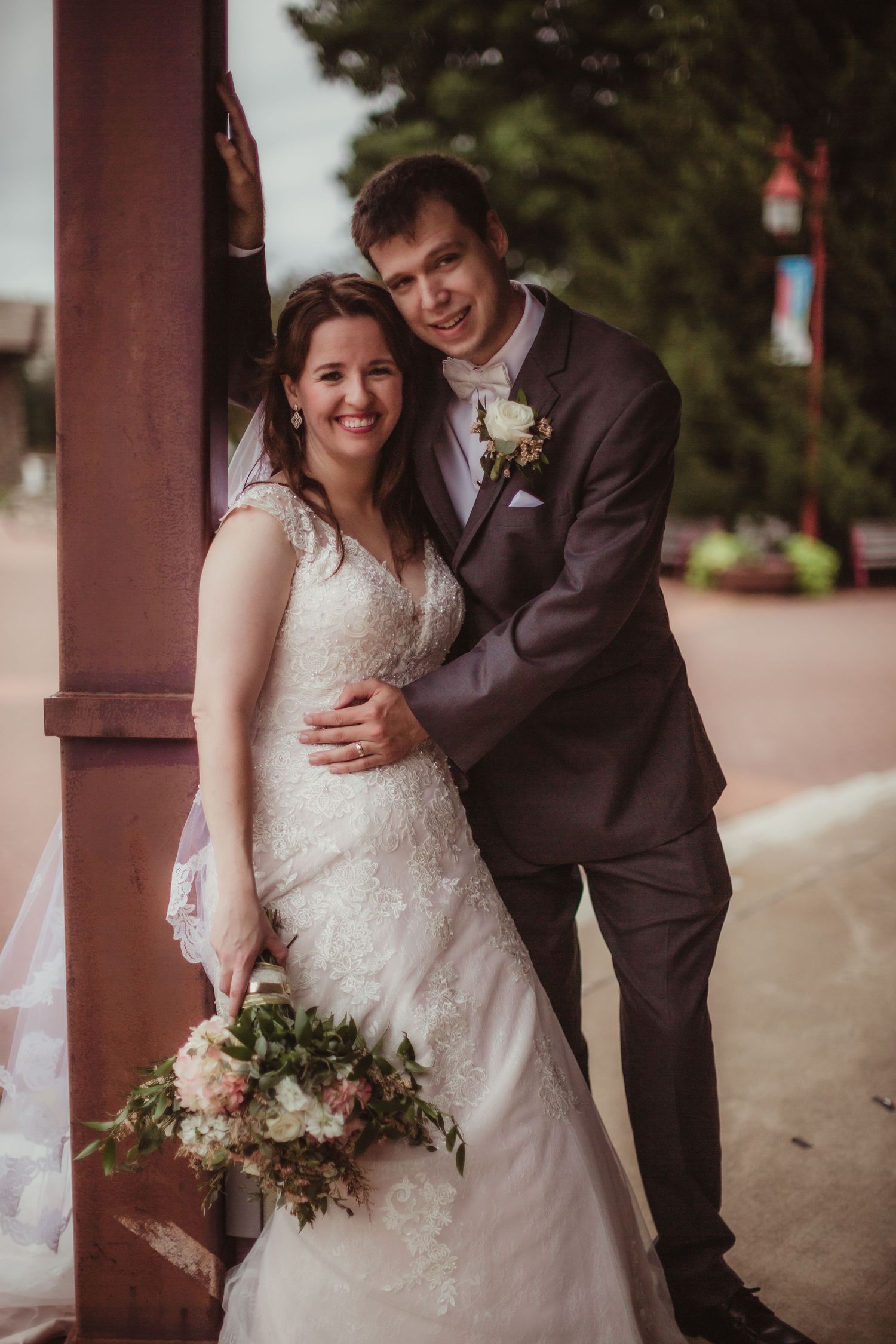 Romantic wedding portraits showcase couple's intimate moments under covered walkway.