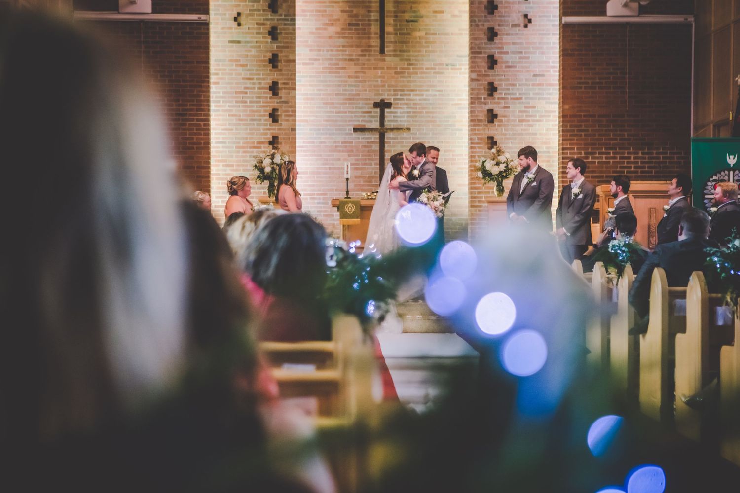 Blurred wedding ceremony in progress with bokeh lights in church setting.