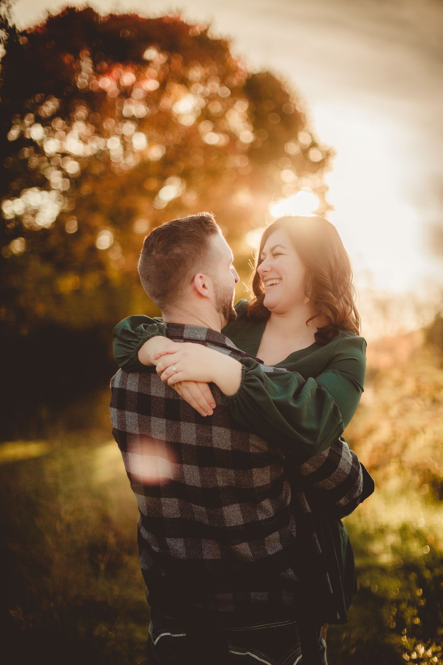 A tender moment shared between two people during sunset with golden bokeh lighting effects.