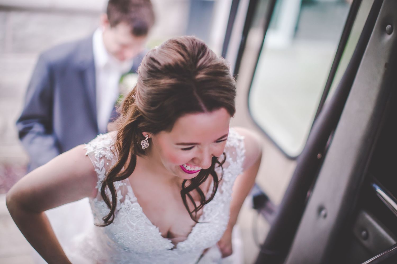 Candid moment captured as person in white dress enters vehicle with excitement.
