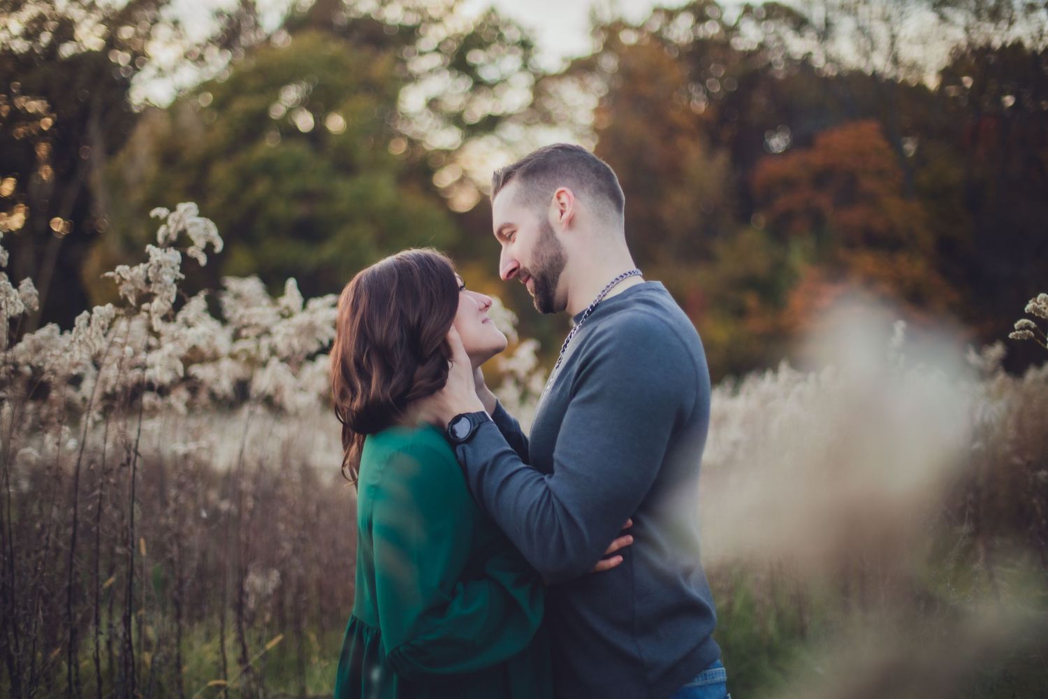 Romantic outdoor portrait of couple among dried autumn flowers.