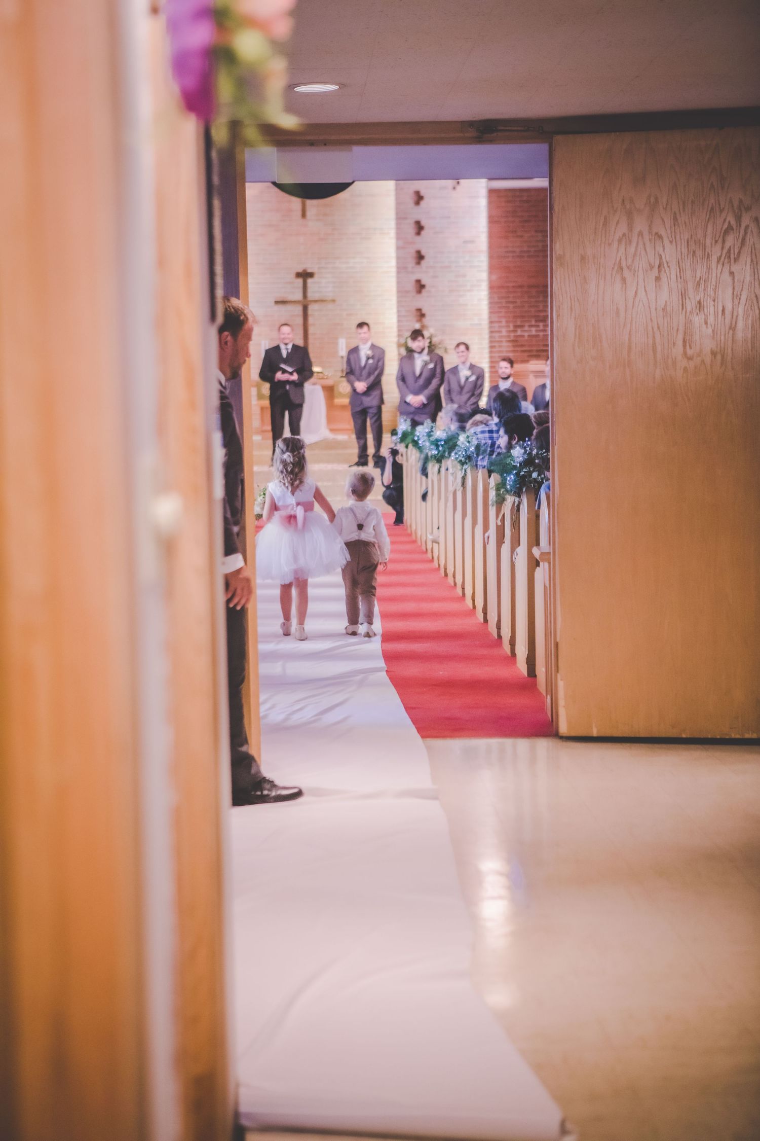 Church corridor with red carpet and wooden pews visible in the background.