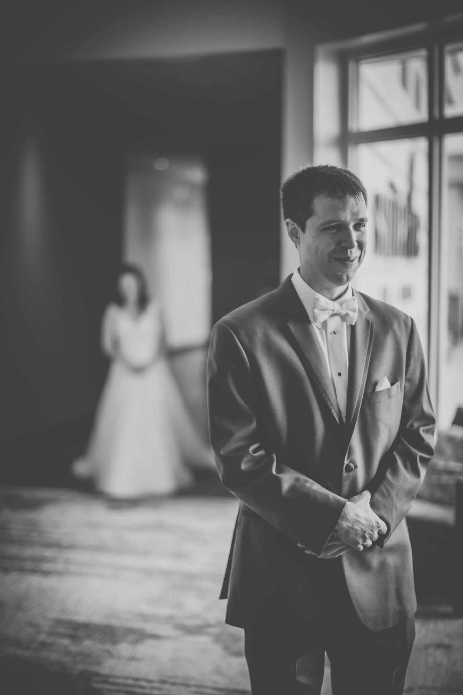 Black and white wedding portrait with silhouette in background.