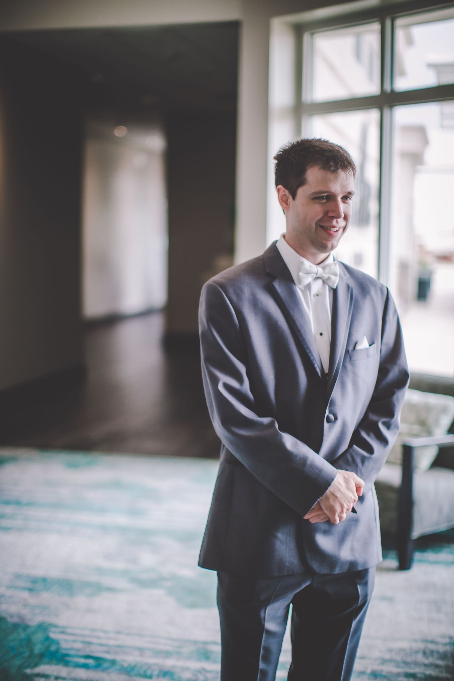 Classic wedding day portrait in a sunlit room with formal attire.