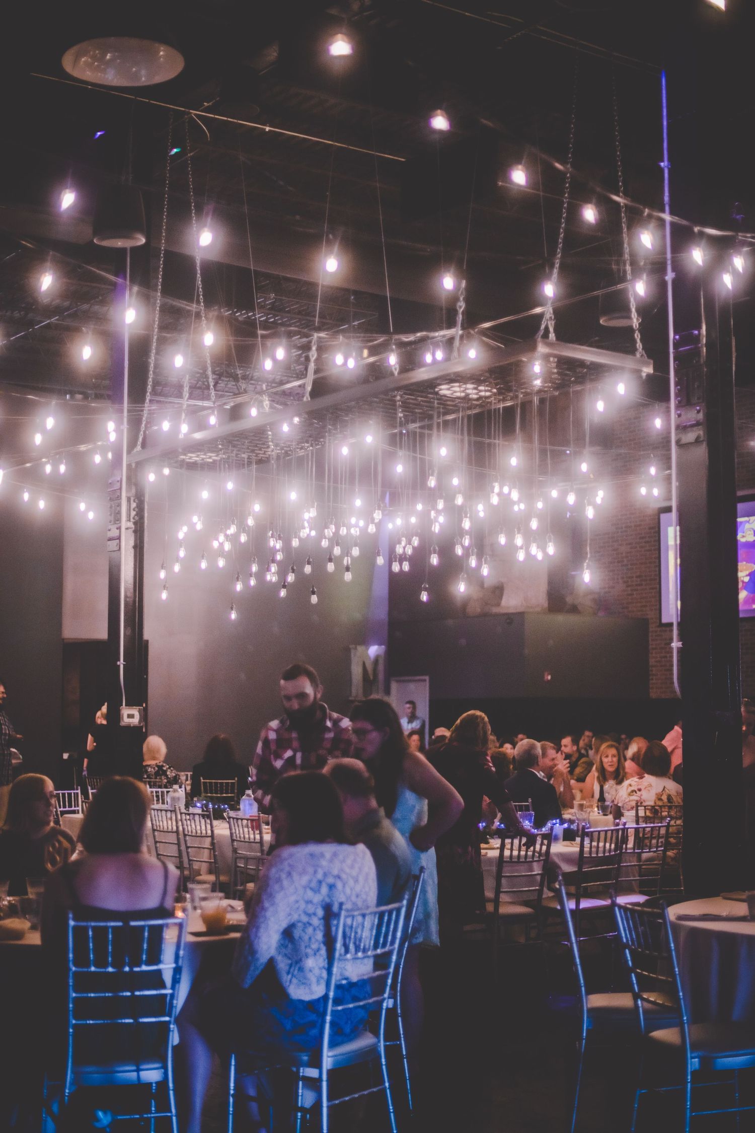 Wedding reception venue with twinkling string lights creating magical ambiance overhead.