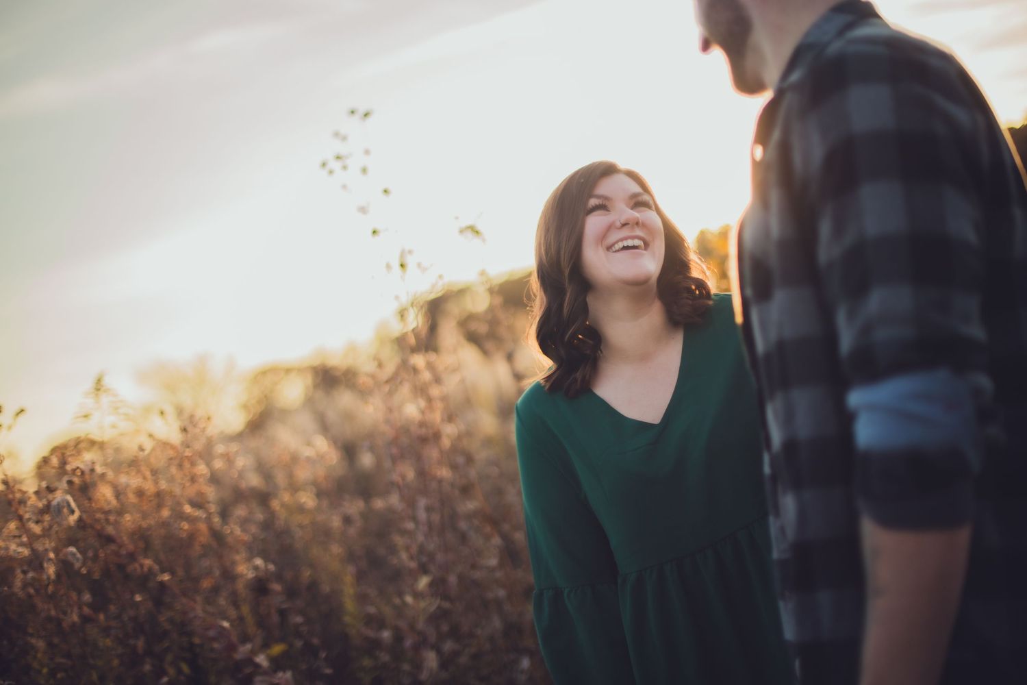 Candid moment of joy captured between couple in autumn field.