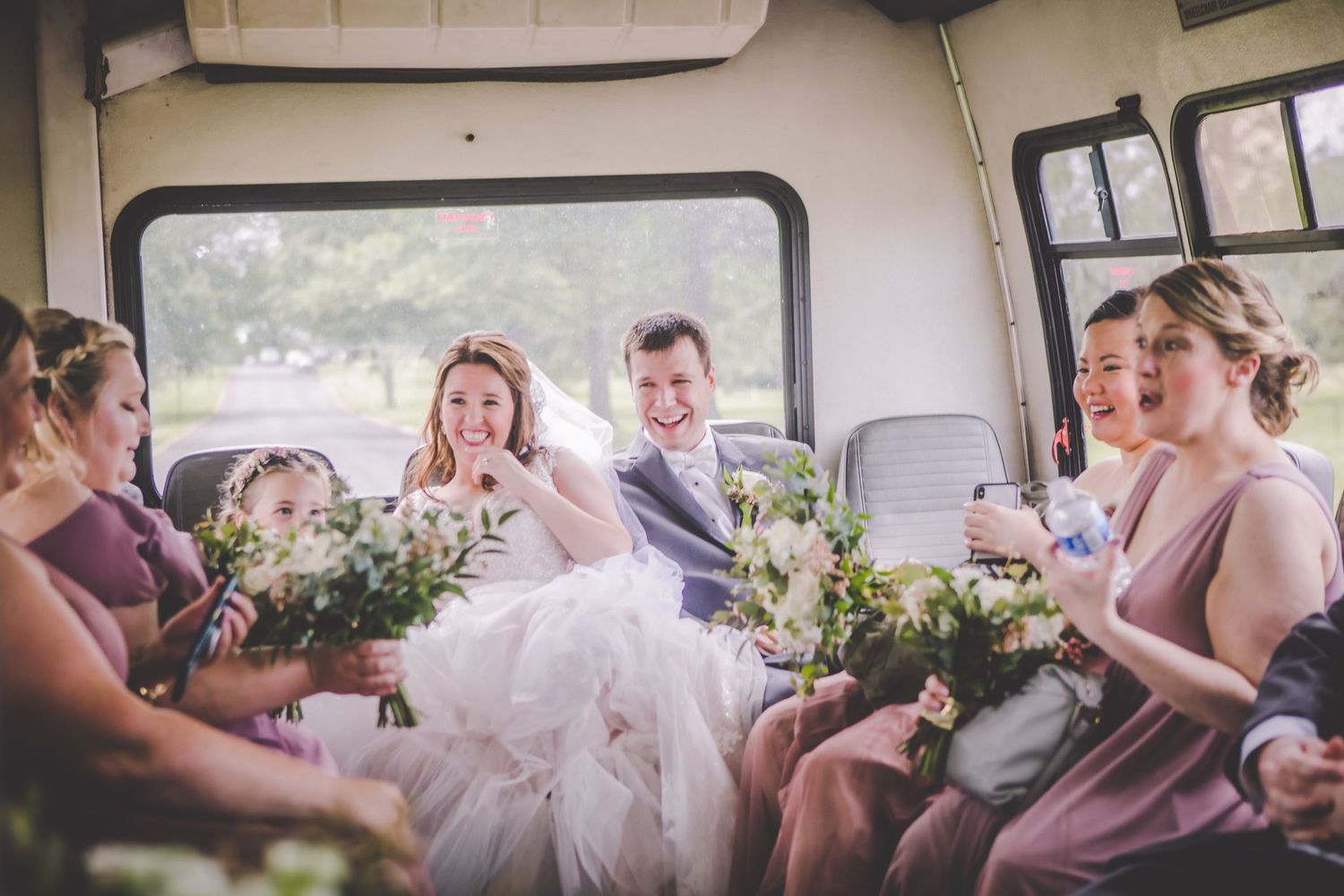 Wedding guests socializing and celebrating inside decorated party bus.