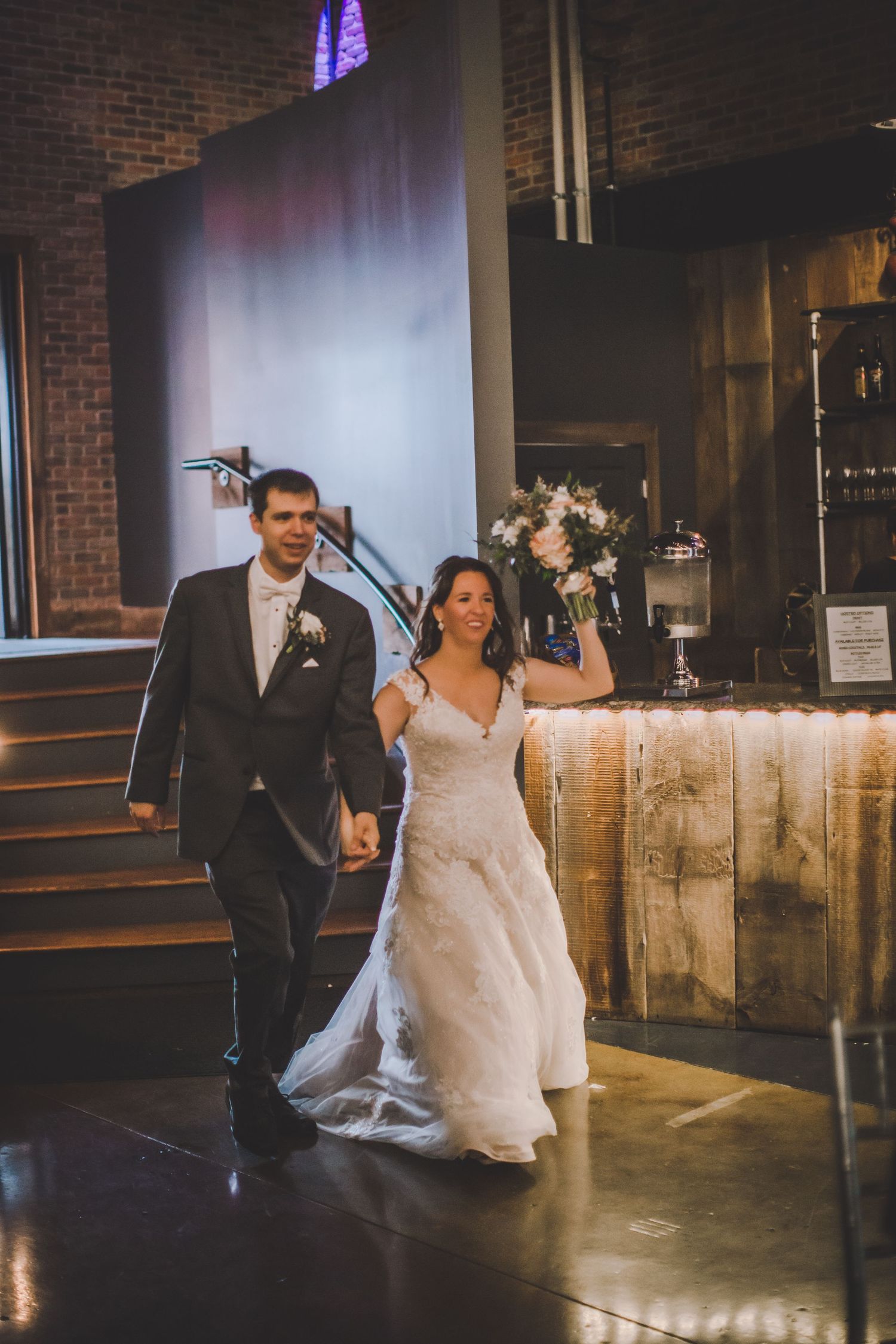 Cinematic wedding sequence shows couple's entrance in modern industrial space with brick walls.