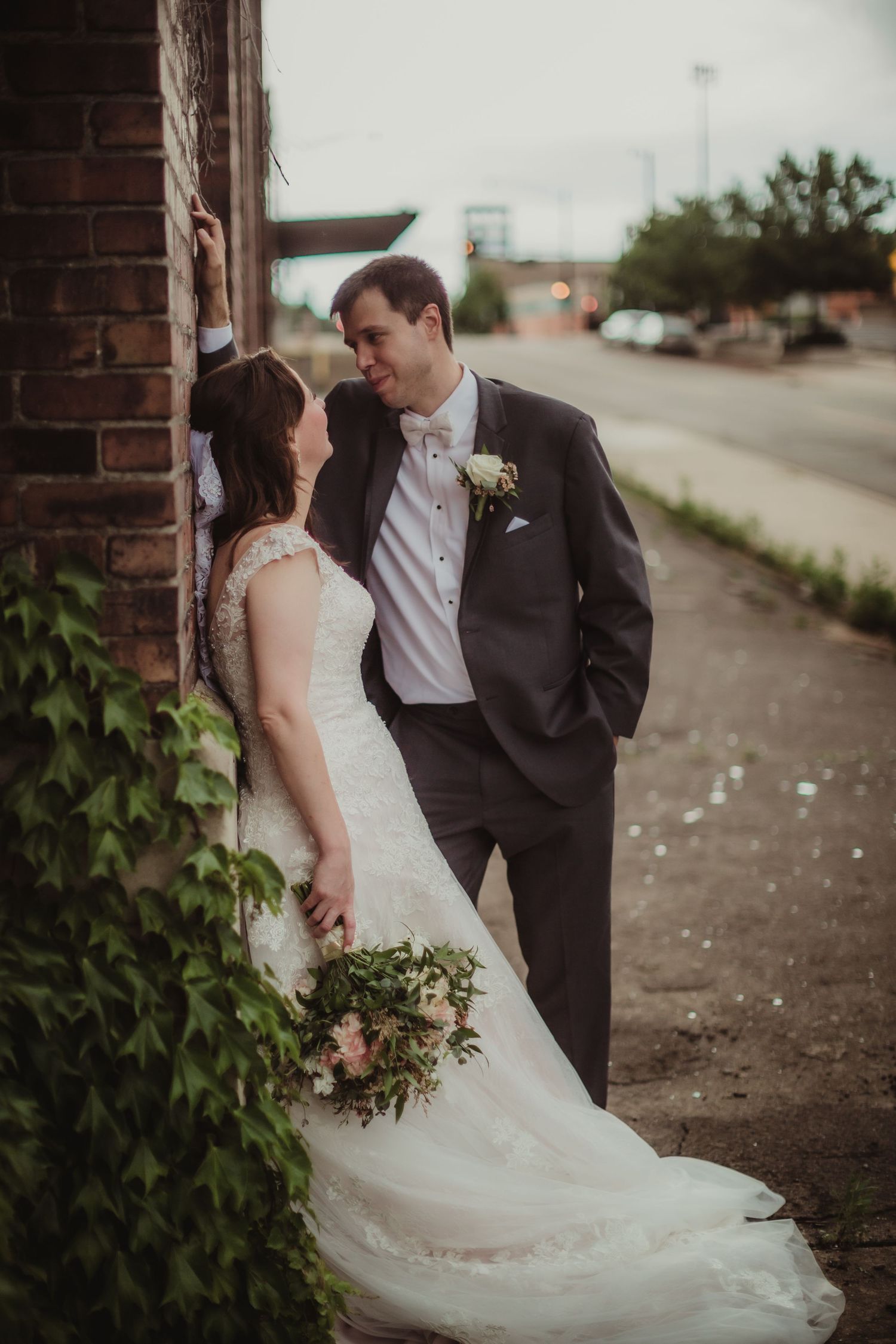Artistic wedding portrait showing couple's intimate moment against industrial backdrop.