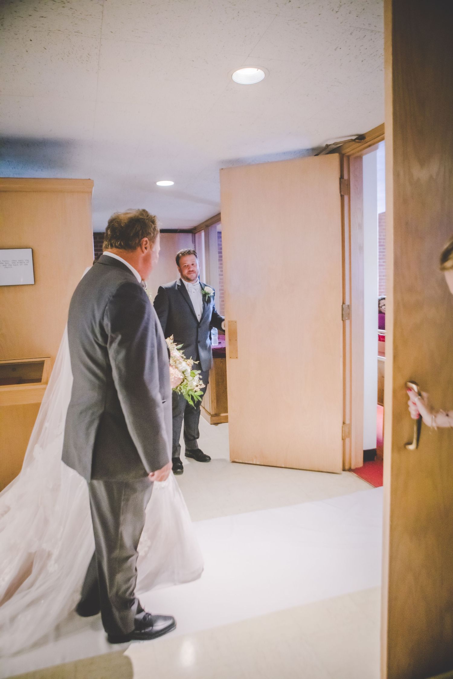 Church hallway with wedding party members walking through.
