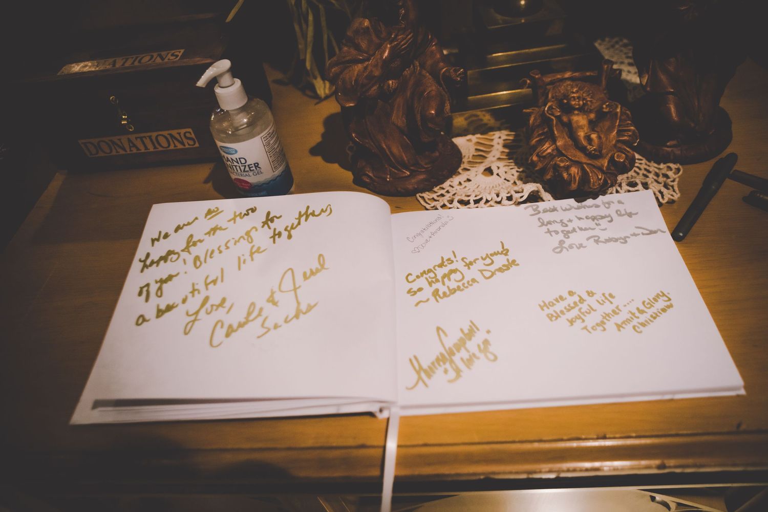 A wedding guestbook displayed open with handwritten messages and signatures from guests.