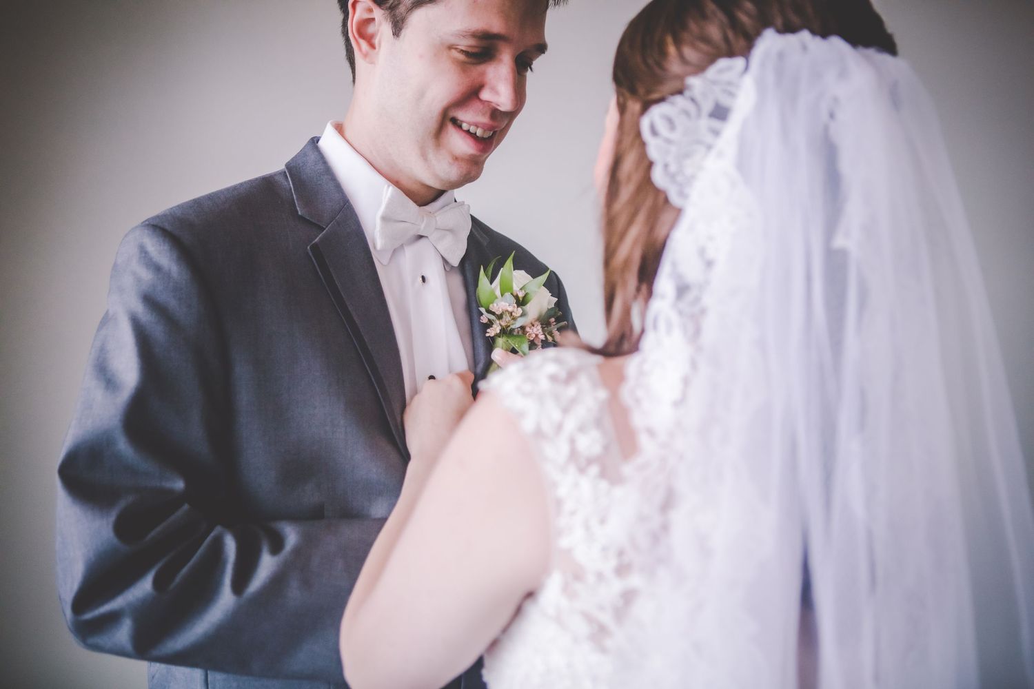 Close-up wedding moment with soft lighting and delicate lace details.