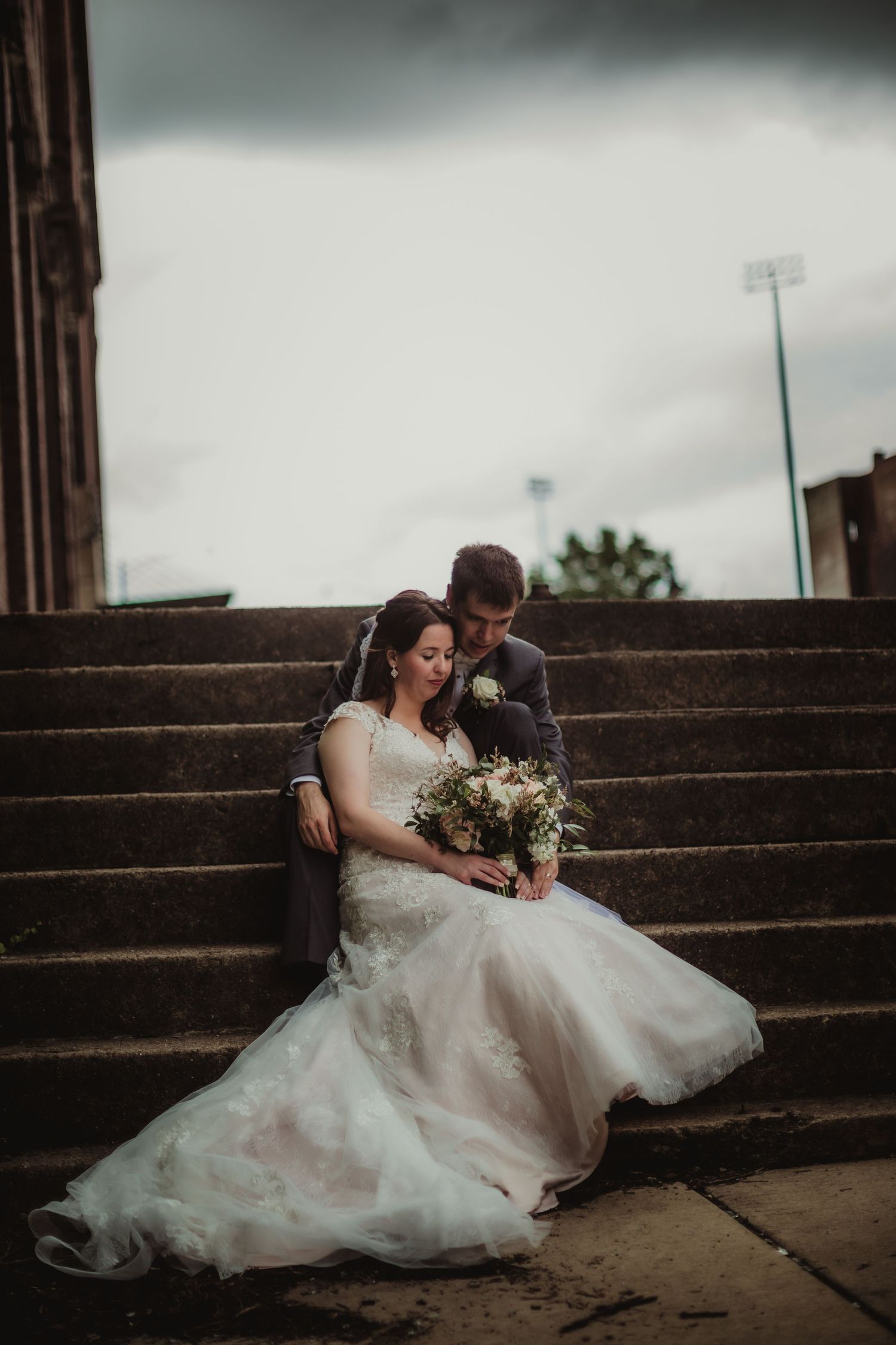 Intimate wedding photo capturing a couple's connection on urban steps.