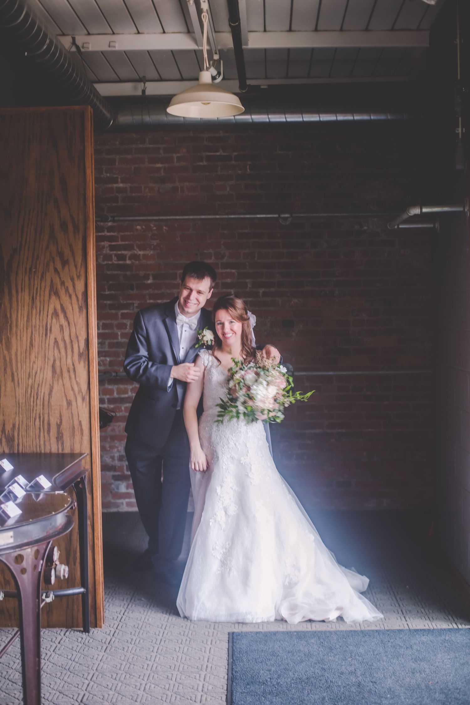 Wedding portrait in industrial venue with exposed brick and wooden accents.