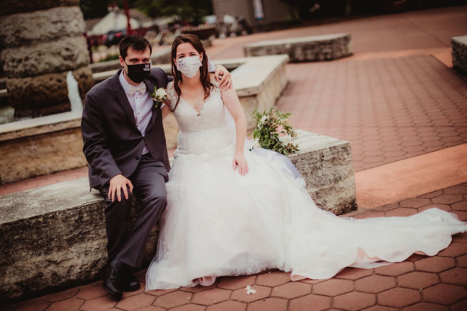 Newlyweds share intimate moments during outdoor photo session on brick walkway.