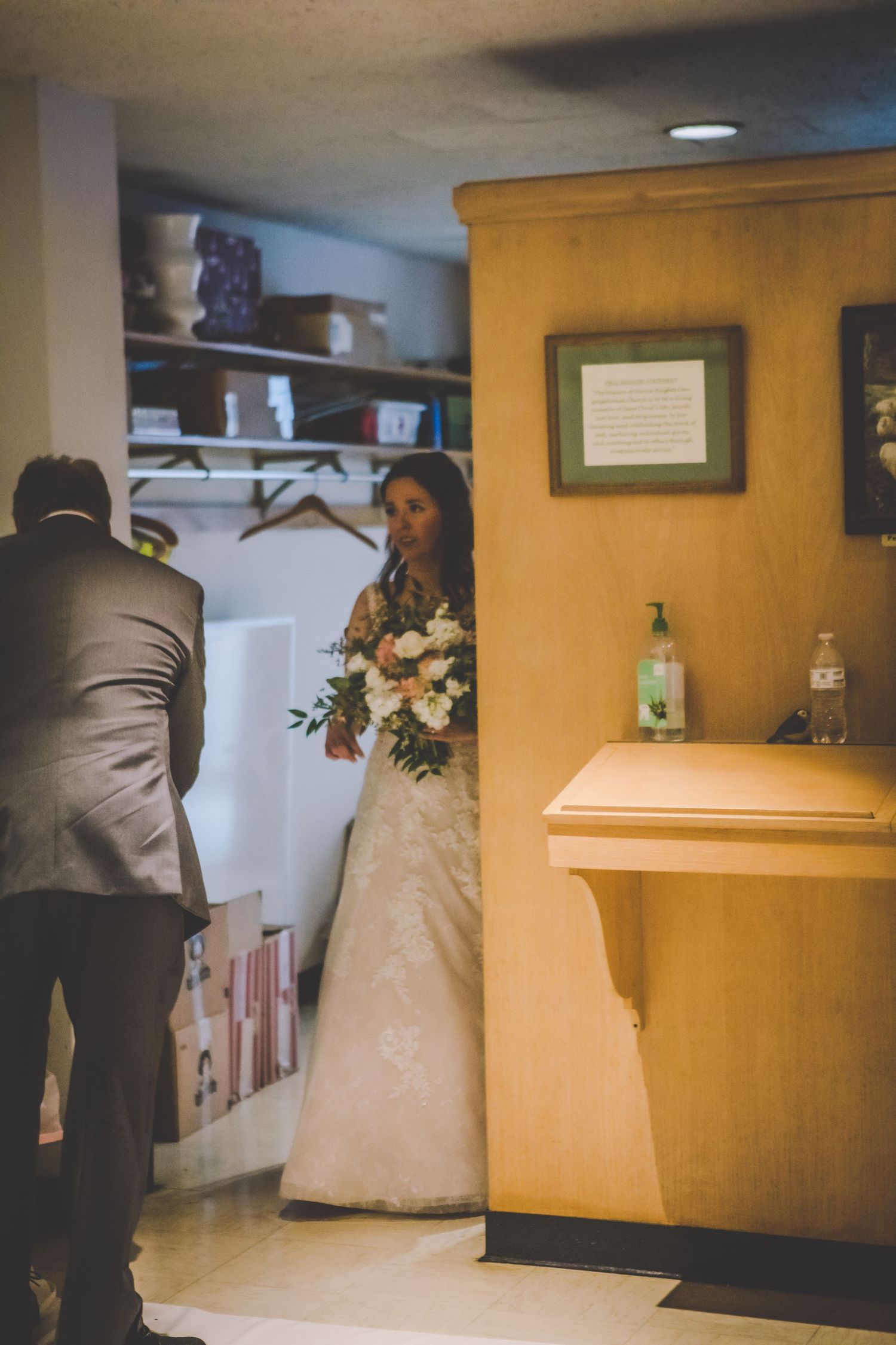 Wedding ceremony preparations in a dimly lit church hallway.