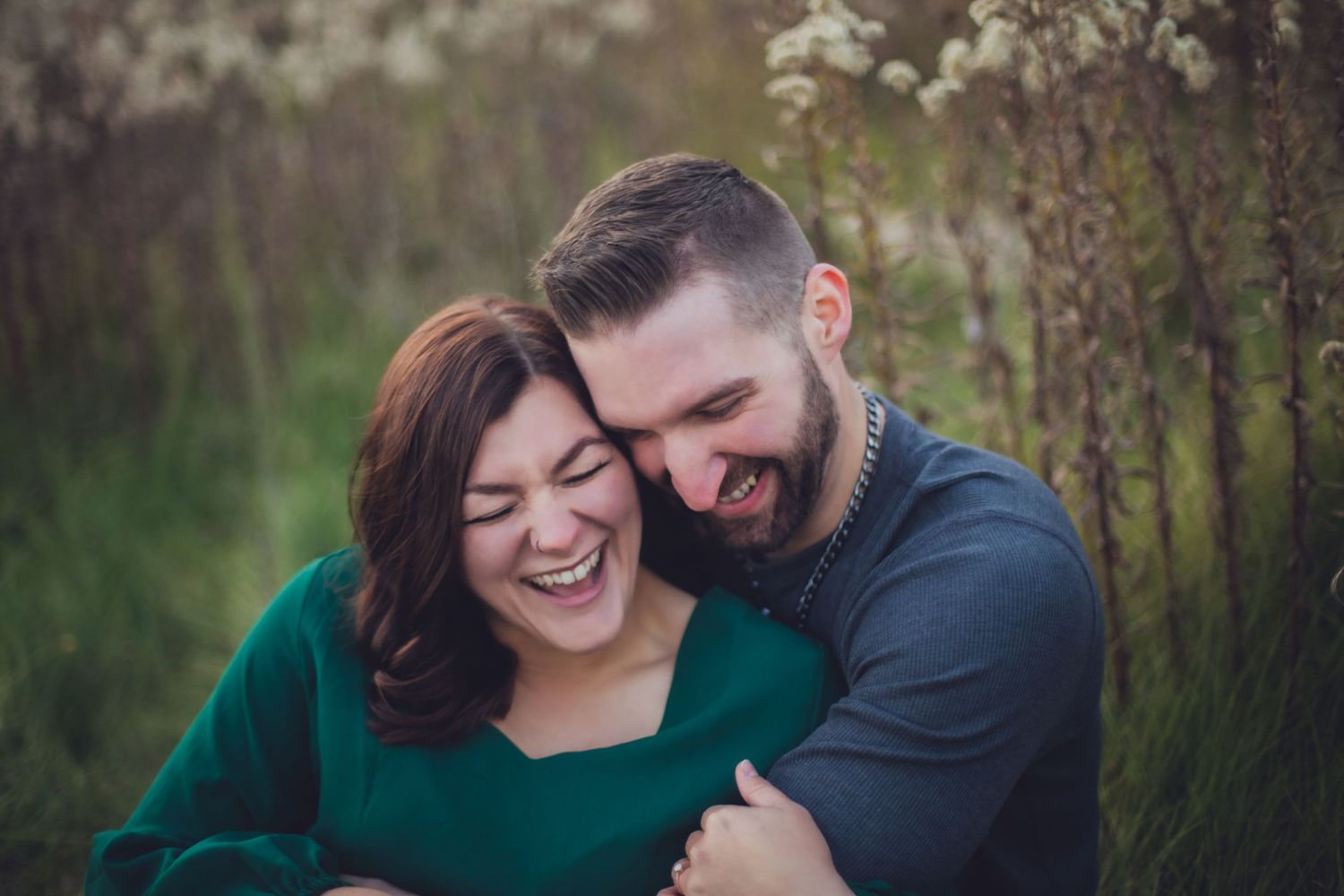 Couple sharing joyful moment while embracing in outdoor nature setting.