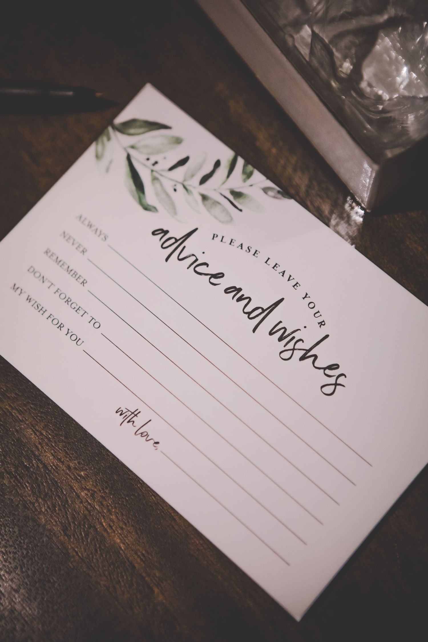 An elegant wedding advice card with greenery design and calligraphy text.