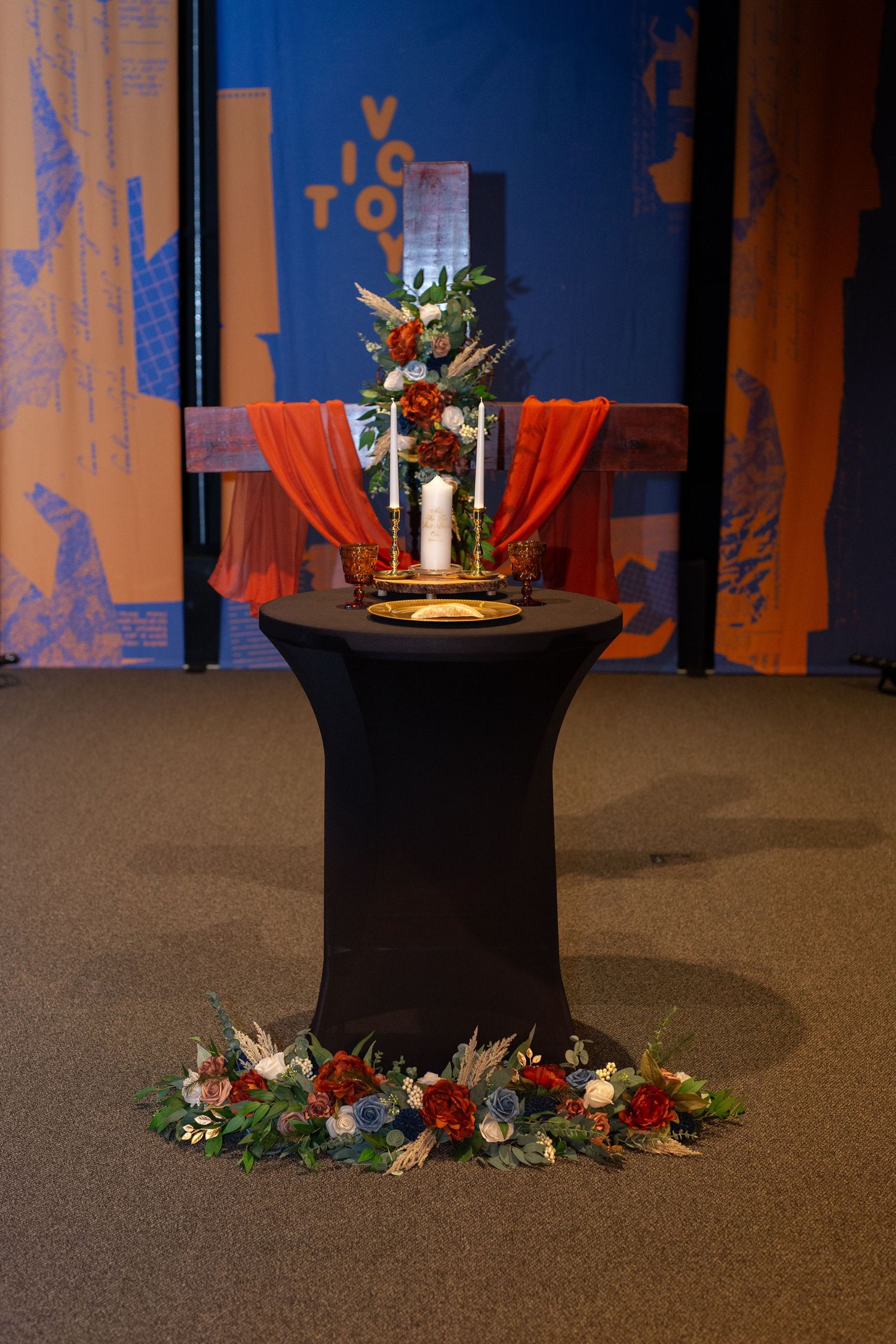 Elegant wedding ceremony setup with black pillars decorated with floral arrangements and candles.