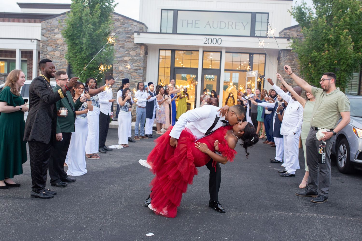 Wedding party dancing and celebrating on outdoor street.