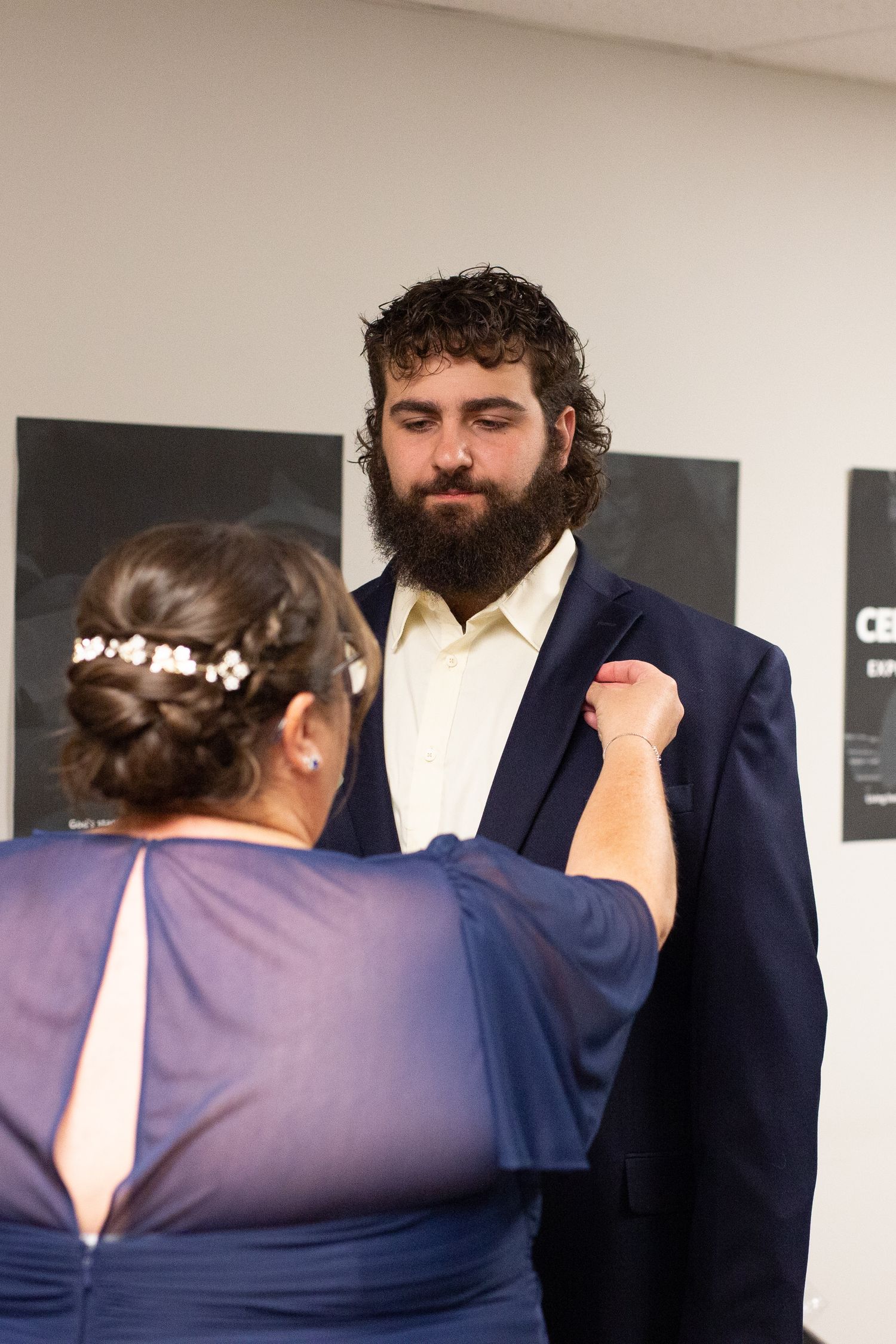 Wedding preparation scene with attendants in navy and purple attire.