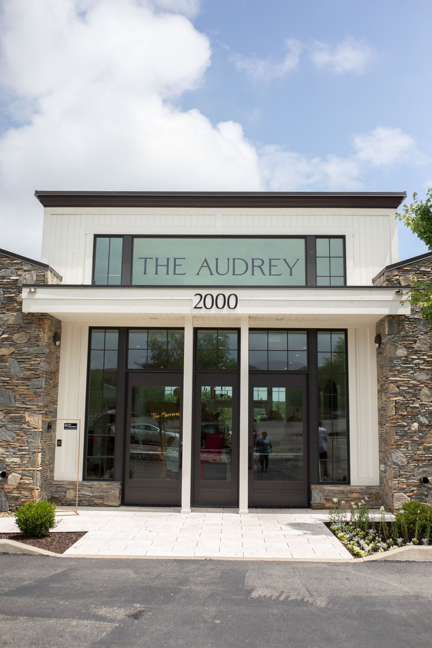 Modern white building exterior with stone accents and 'The Audrey' signage.