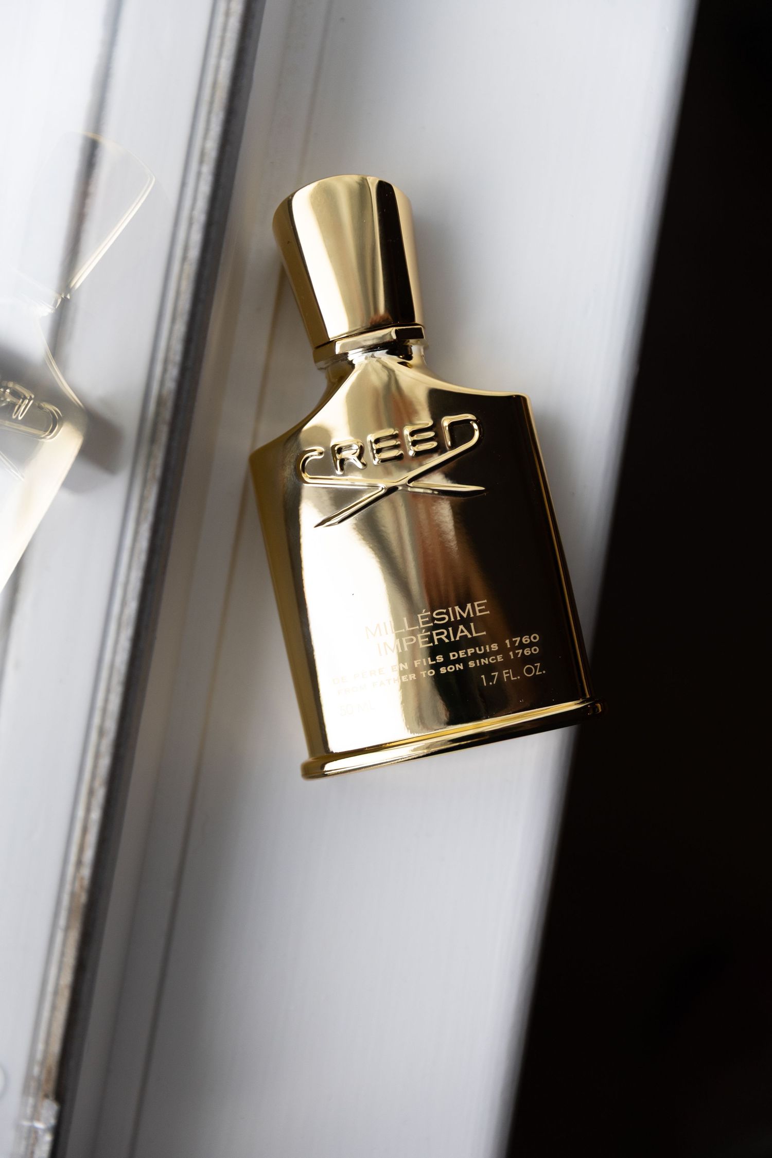 Elegant gold perfume bottles displayed near a window with natural lighting.