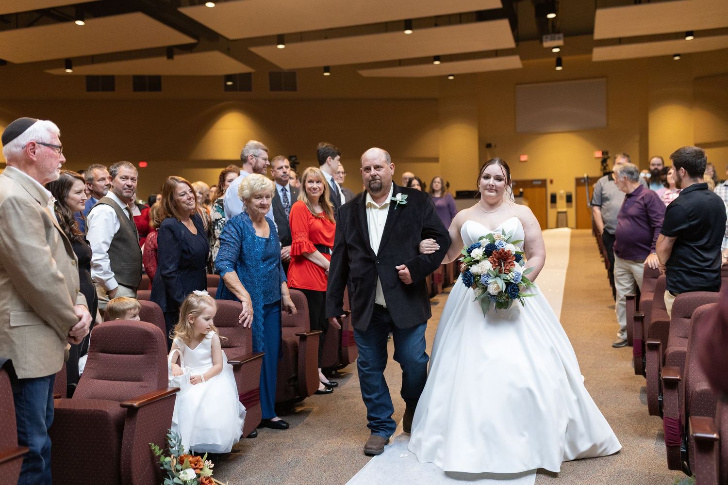 Wedding ceremony in progress with guests seated in an elegant venue hall.