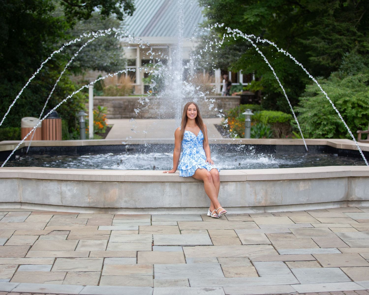 A stone fountain with cascading water creates an elegant backdrop at an outdoor venue.