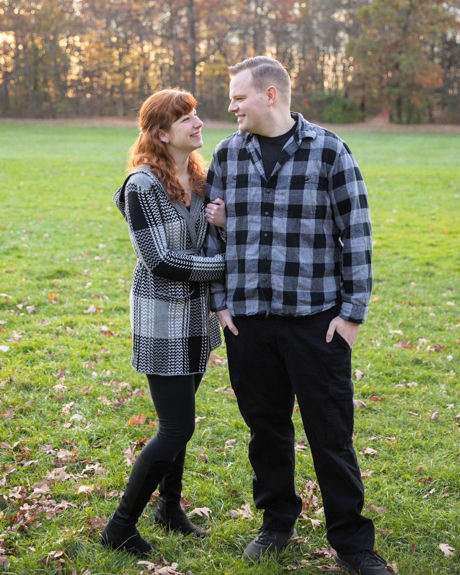 Candid family interactions in a fall field with plaid clothing and natural poses.